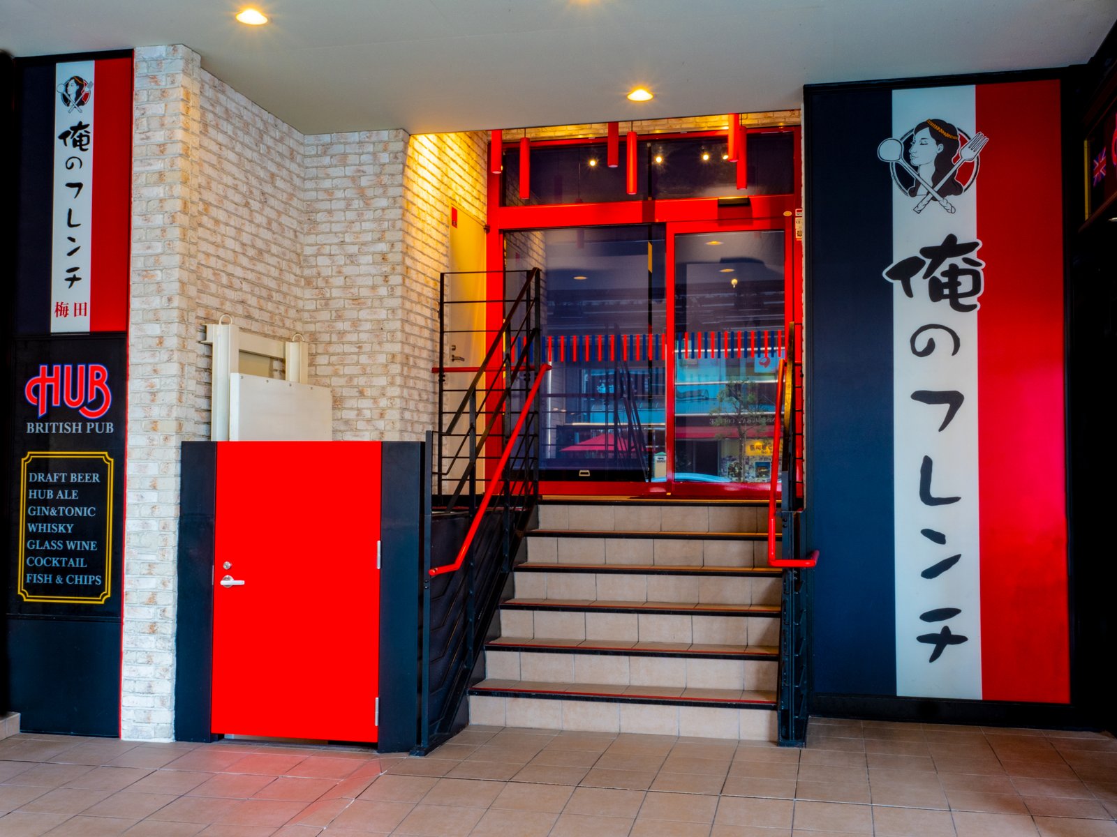 俺のフレンチ 梅田店の入口。赤・紺・白の縦看板に「俺のフレンチ」と書かれている