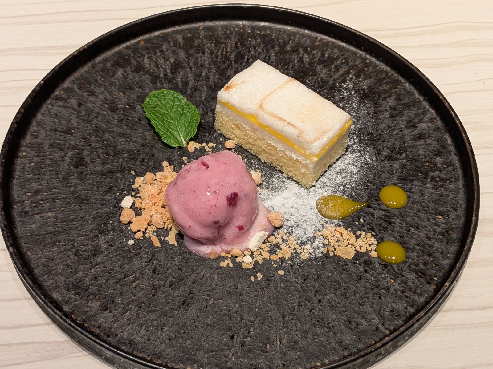 ミントとピンクのシャーベットが添えられた、本日のケーキの盛り合わせ