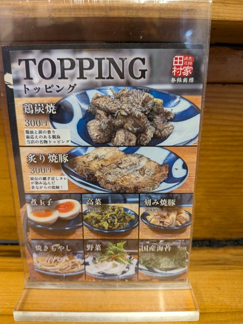 田村家のトッピングのメニュー。鶏炭焼、炙り焼豚、煮玉子などの写真つき