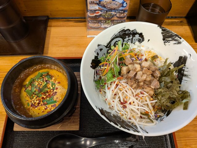 辛つけ麺。もやしや鶏肉、野菜が乗った麺と、辛いつけ汁