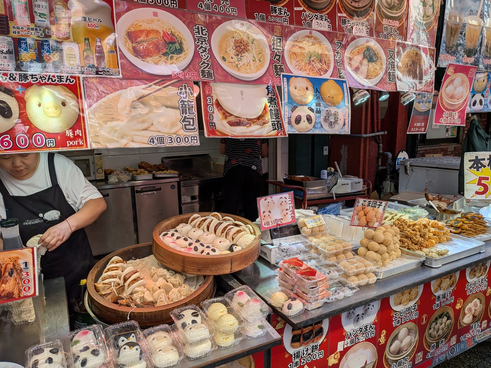 屋台の店先。蒸籠や、メニュー写真の看板が並んでいる