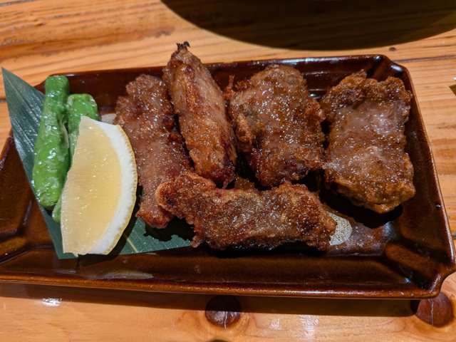 レモンとししとうが添えられたマグロの竜田揚げ