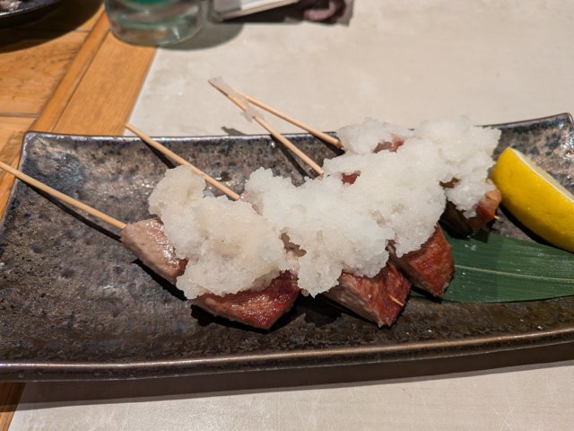 大根おろしがたっぷり乗った中トロの串焼き